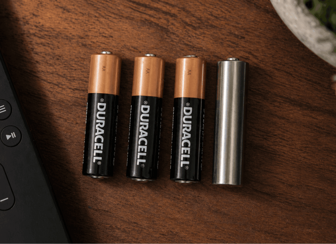 Keepcrypt Cell hidden among real AAA Duracell batteries on a wood surface